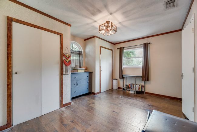 Bedroom featuring wood-type flooring, baseboards, crown molding, and visible vents | Image 17