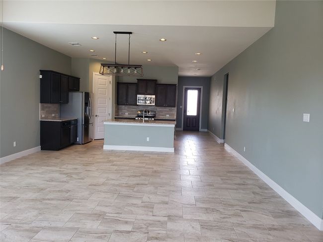 Kitchen featuring appliances with stainless steel finishes, tasteful backsplash, light countertops, recessed lighting, and a kitchen island with sink | Image 4