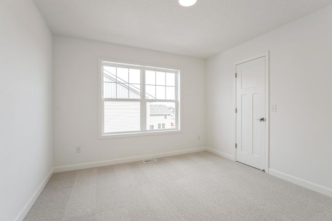 Photo is of the actual home. One of three generously sized secondary bedrooms with a spacious closet. | Image 12