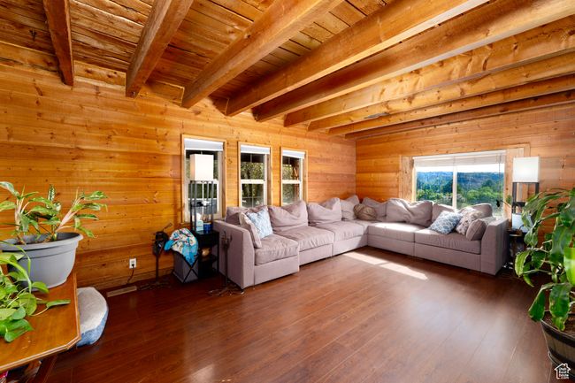 Living room featuring beam ceiling, wooden walls, wood-type flooring, and wood ceiling | Image 17