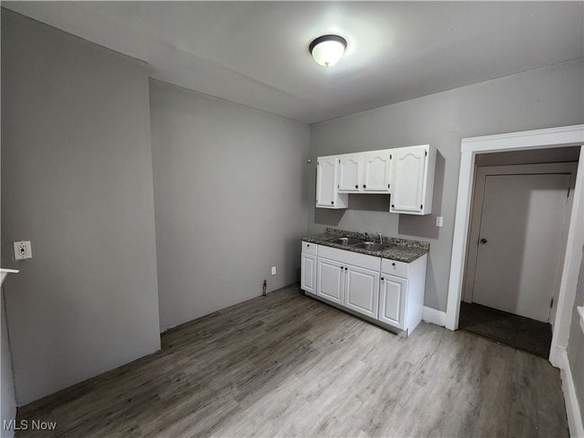Kitchen with white cabinets, sink, and light wood-type flooring | Image 12