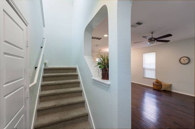 Stairway with wood finished floors, arched walkways, and ceiling fan | Image 24