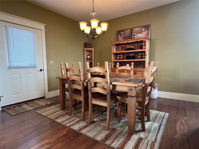 Dining space featuring a chandelier and wood finished floors | Image 6