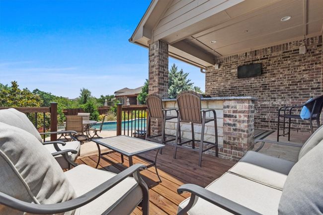 A custom pool and spa surrounded by native flowers and lush professional landscaping, all framed by Hill Country views that remind you why you moved to Texas in the first place. | Image 36