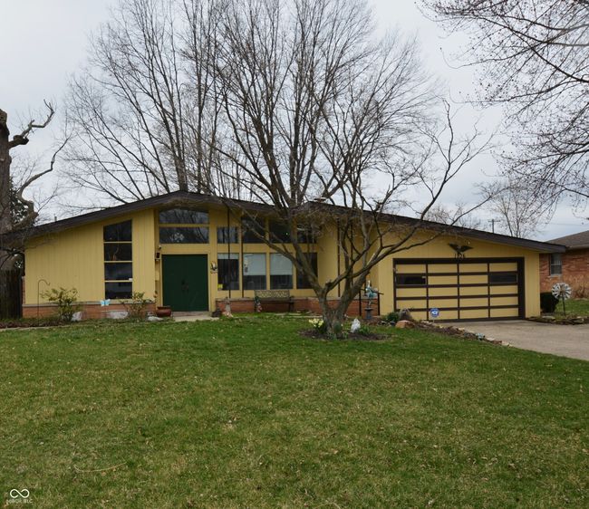 mid-century home with a front yard, an attached garage, and concrete driveway | Image 7