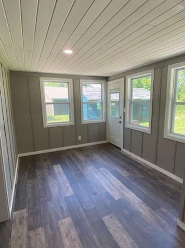 Spare room featuring dark wood-type flooring and wood ceiling | Image 18