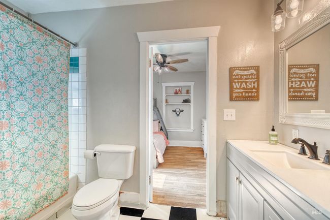 Ensuite bathroom with vanity, a ceiling fan, shower / bath combo, and built in shelves | Image 26