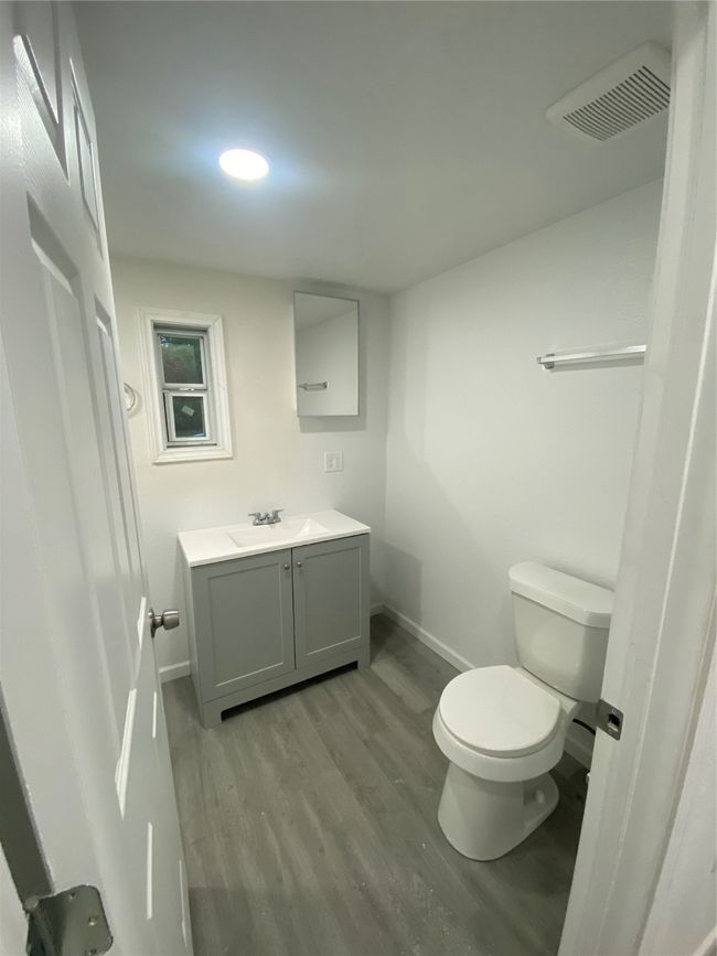 Bathroom featuring wood finished floors, toilet, baseboards, and vanity | Image 11