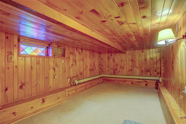 Bonus room featuring wooden ceiling, unfinished concrete flooring, and wooden walls | Image 42