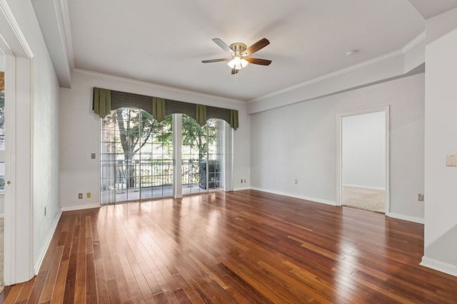 Unfurnished room with ceiling fan, hardwood / wood-style flooring, and crown molding | Image 10