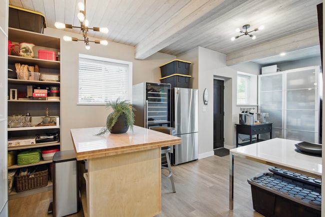 Kitchen featuring a chandelier, beamed ceiling, wood ceiling, freestanding refrigerator, and light wood-style floors | Image 29