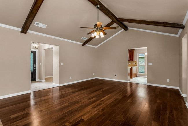 Unfurnished living room featuring a ceiling fan, wood-type flooring, and a chandelier | Image 4