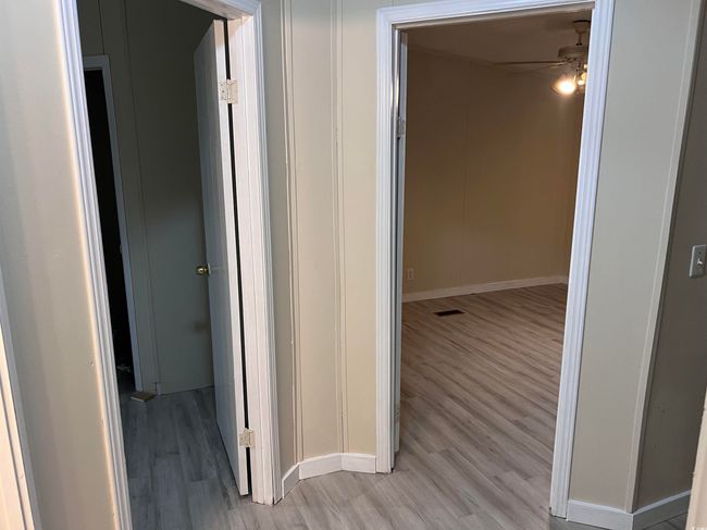 Spare room featuring light wood-style flooring, baseboards, and a decorative wall | Image 22
