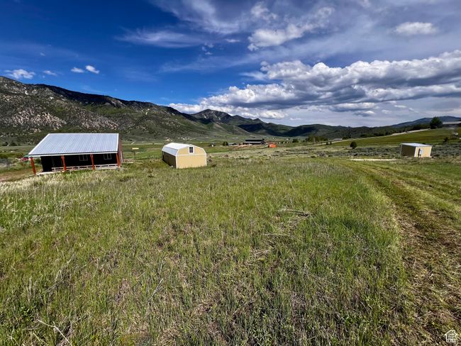 View of yard featuring an outdoor structure, a mountain view, a view of countryside, and a pole building | Image 19