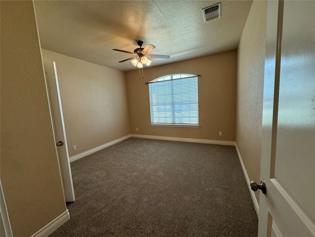 4 Carpeted spare room with baseboards, a ceiling fan, visible vents, and a textured ceiling | Image 17