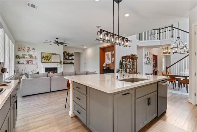 Kitchen featuring ceiling fan with notable chandelier, a sink, gray cabinetry, and visible vents | Image 9