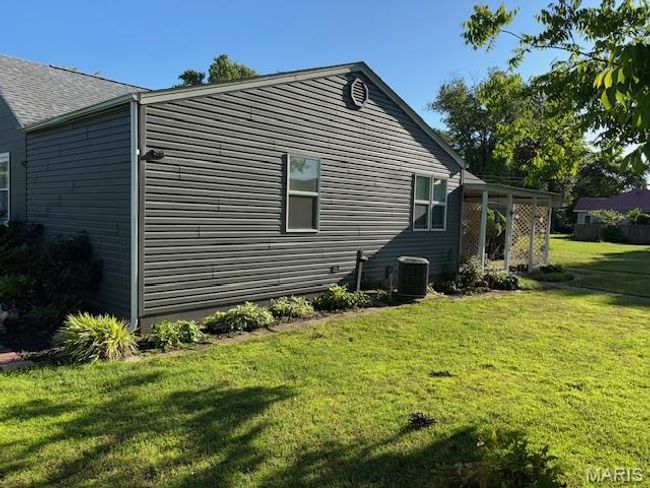 View of side of home featuring a yard and central AC | Image 6