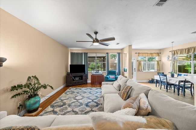 Living room featuring baseboards, a ceiling fan, wood finished floors, and a textured ceiling | Image 15