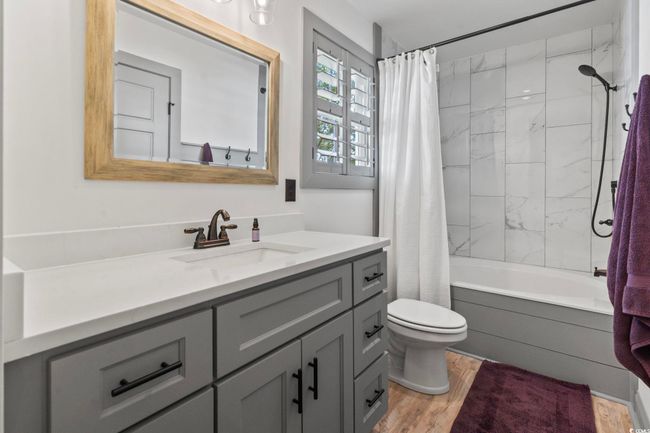 Bathroom with wood finished floors, shower / tub combo, toilet, and vanity | Image 19