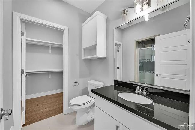 Bathroom with a shower stall, vanity, and a spacious closet | Image 11