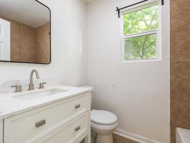 Full bathroom with toilet, vanity, a bathtub, and baseboards | Image 20