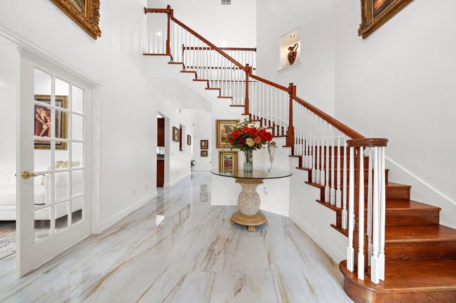Elegant foyer with a grand staircase and polished floors | Image 5