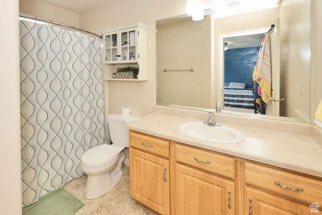Bathroom featuring ensuite bath, vanity, a shower with curtain, and toilet | Image 10
