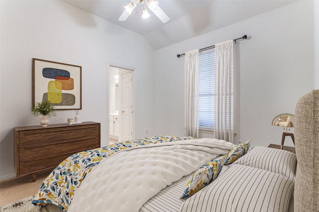 Carpeted bedroom featuring lofted ceiling, a ceiling fan, and connected bathroom | Image 22
