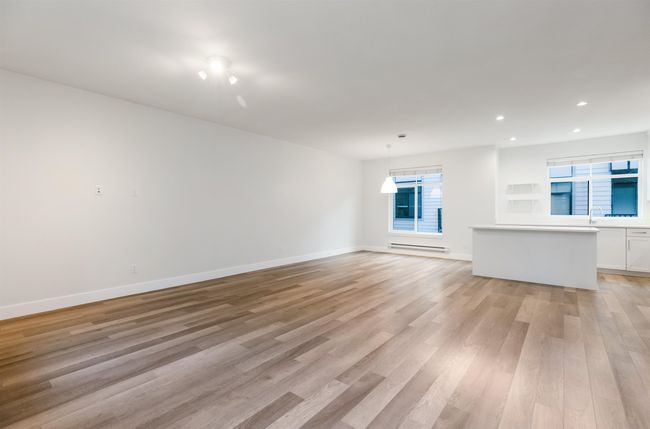 Interior space featuring baseboards, recessed lighting, a baseboard radiator, and light wood-type flooring | Image 4