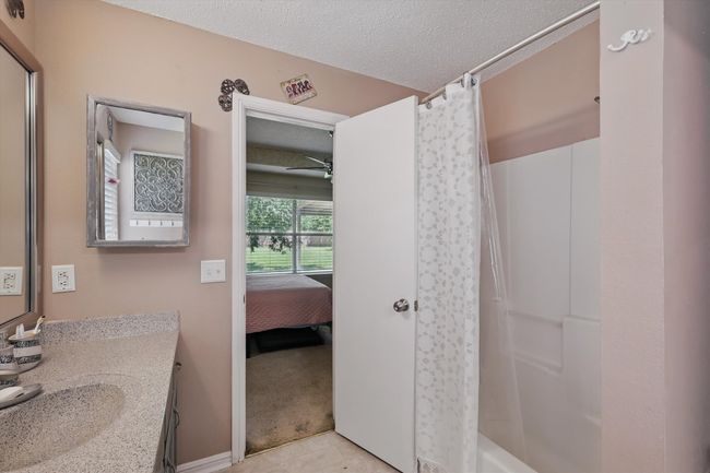 Bathroom with a ceiling fan, vanity, ensuite bathroom, and a textured ceiling | Image 24