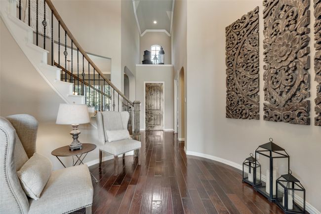 Entryway featuring arched walkways, hardwood / wood-style floors, healthy amount of natural light, stairway, and a high ceiling | Image 19