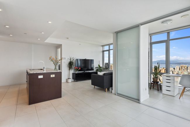 Kitchen featuring light stone counters, a sink, expansive windows, and open floor plan | Image 8