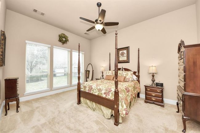 The Primary bedroom is spacious and bright with large windows which allow for a clear view of the backyard. | Image 14