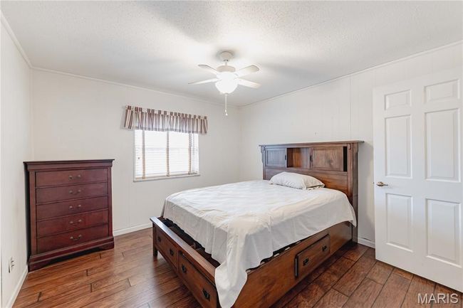 Bedroom with hardwood / wood-style flooring, ceiling fan, and a textured ceiling | Image 39