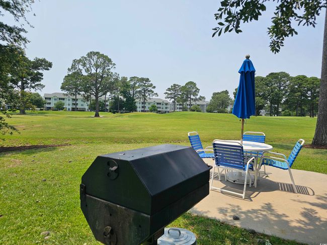 View of green lawn featuring a patio and outdoor dining area | Image 22