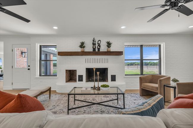 Living area featuring crown molding, wood finished floors, a ceiling fan, and visible vents | Image 15