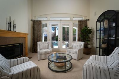 Relax in the living room with one of the three fireplaces while looking out to the sparkling backyard oasis. | Image 3