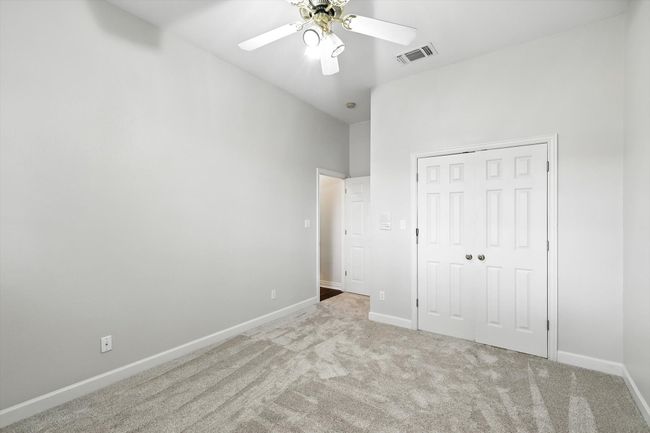 Downstairs bedroom with carpet flooring, a closet, and ceiling fan | Image 17