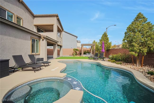 View of pool featuring a fenced backyard, a pool with connected hot tub, and a patio area | Image 28