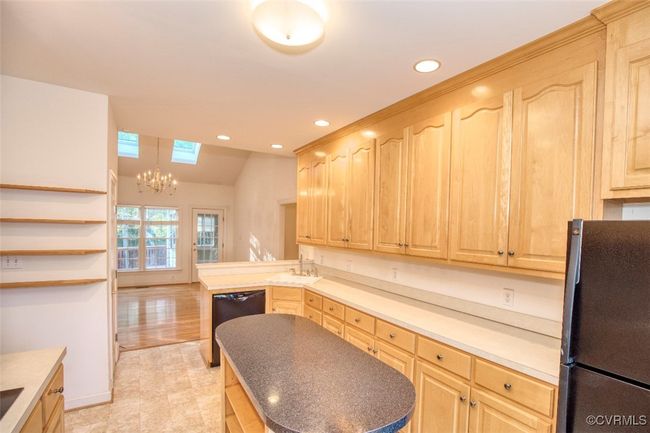 Kitchen with light brown cabinets, black appliances, a chandelier, and recessed lighting | Image 9