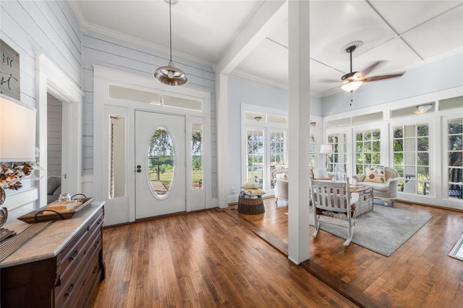 Foyer entrance with a ceiling fan, dark wood-style floors, ornamental molding, and beam ceiling | Image 13