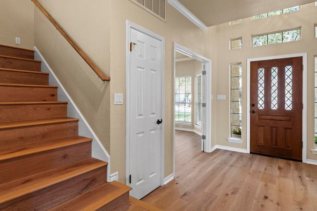 Entrance foyer featuring visible vents, crown molding, baseboards, stairway, and light wood-style floors | Image 17