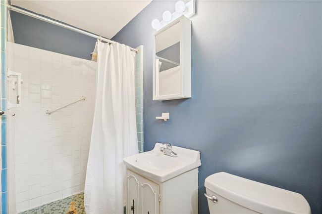 Bathroom with vanity, toilet, and a shower with curtain | Image 21
