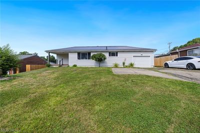 Ranch-style house with a garage and a front lawn | Image 2