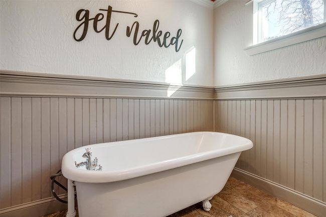 Full bath with a soaking tub, wainscoting, and wood walls | Image 31