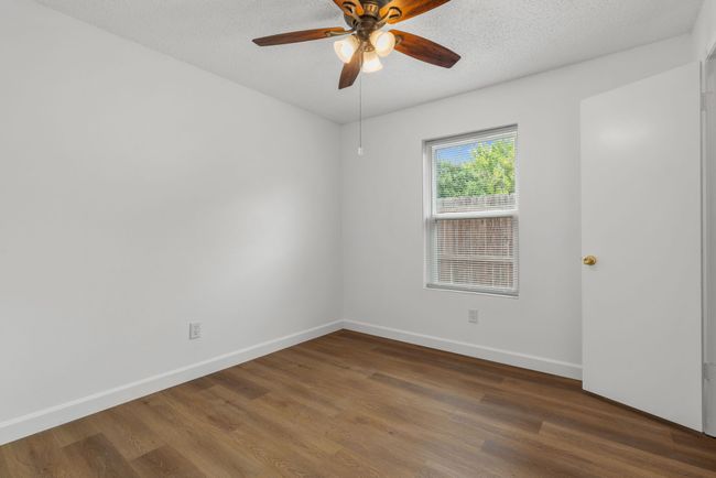 Empty room with wood finished floors, a ceiling fan, and a textured ceiling | Image 27