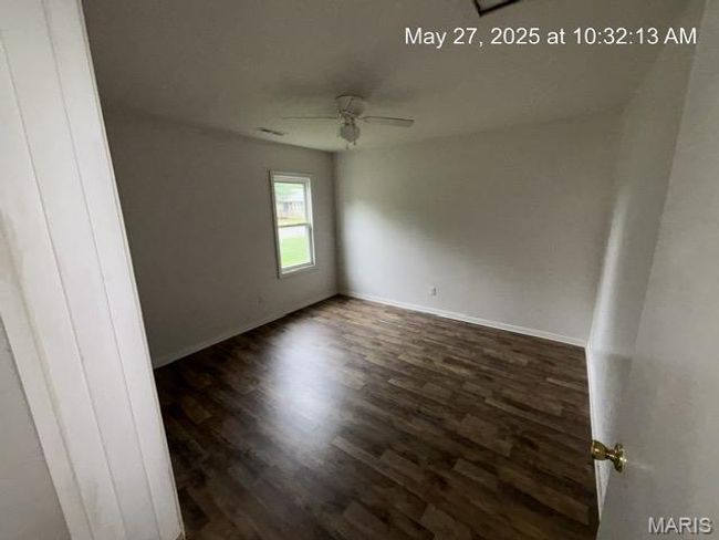 Spare room featuring dark wood-style flooring, ceiling fan, and baseboards | Image 11