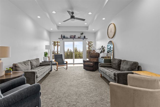 Carpeted living area featuring recessed lighting, ceiling fan, and a towering ceiling | Image 12