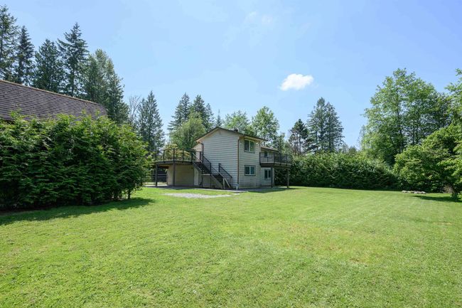 View of green lawn featuring stairway and a wooden deck | Image 6