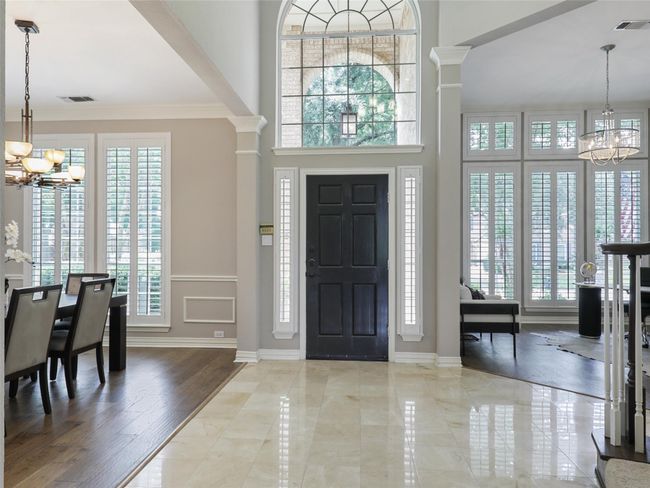Entryway with a chandelier, plenty of natural light, ornate columns, and crown molding | Image 8